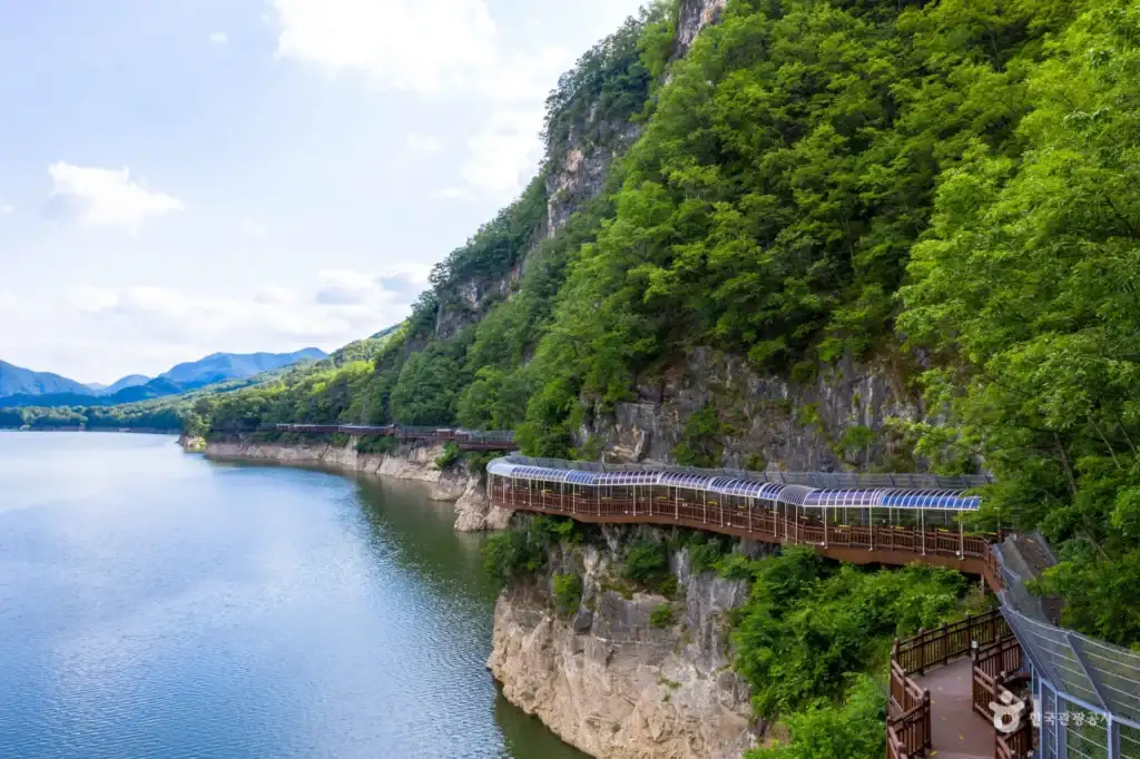 People walking on Danyanggang Jando Trail near a white bridge