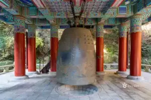 A large traditional bronze bell inside a pavilion