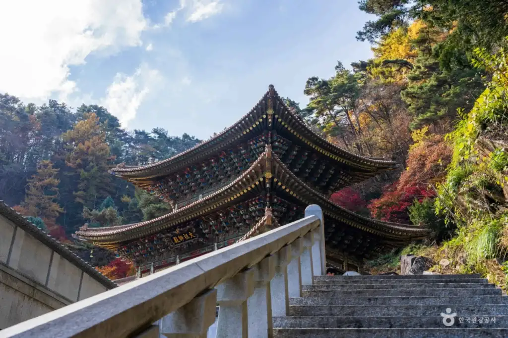 Stone stairs leading up to a grand Korean temple