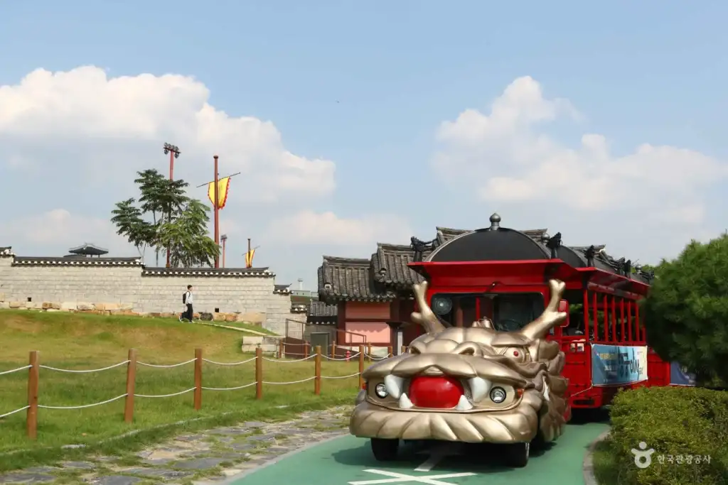 Hwaseong Trolley driving past traditional walls